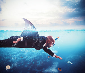 Businessman with fin shark swims under water