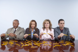 Stressed people breaking pencils in office