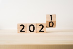 Business and design concept - surreal abstract geometric floating wooden cube with word 2020 and 2019 concept on wood floor and white background