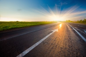 black asphalt road with arrow to sunset